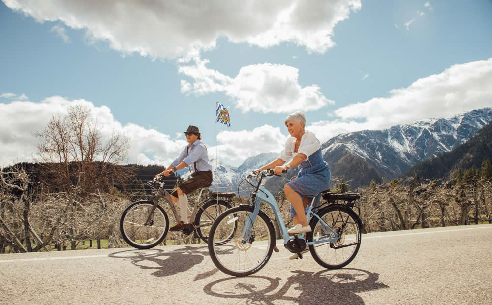 couple biking in leavenworth wa - electric bicycles tours with snow covered mountains